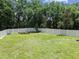 Large, fenced backyard with well-maintained lawn and garden beds, offering privacy and space for outdoor activities at 1460 Kensington Woods Dr, Lutz, FL 33549
