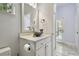 Stylish bathroom featuring white cabinets, unique decorative bowl sink, and tile flooring at 1460 Kensington Woods Dr, Lutz, FL 33549