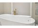 The bathroom has a sleek, standalone soaking tub with a modern faucet and a large window at 1460 Kensington Woods Dr, Lutz, FL 33549