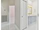 Bathroom with double doors, tiled floors, and modern fixtures at 1460 Kensington Woods Dr, Lutz, FL 33549