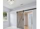 Bright bedroom with stylish light fixture and barn door leading to spacious walk-in closet at 1460 Kensington Woods Dr, Lutz, FL 33549