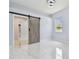 Bright bedroom featuring marble floors, a barn door, and a window at 1460 Kensington Woods Dr, Lutz, FL 33549