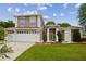 Charming two-story home featuring a manicured lawn, beautiful landscaping, and a two-car garage at 1460 Kensington Woods Dr, Lutz, FL 33549