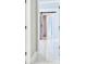 Bright hallway with modern light-colored floors leads to rooms, featuring a sliding barn door at 1460 Kensington Woods Dr, Lutz, FL 33549