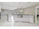 Spacious kitchen with a stainless steel farmhouse sink, white cabinets, and elegant pendant lighting at 1460 Kensington Woods Dr, Lutz, FL 33549