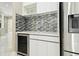 Dry bar with wine fridge and white cabinets at 1460 Kensington Woods Dr, Lutz, FL 33549