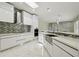 Bright kitchen featuring waterfall island, stone backsplash, stainless appliances, and marble floors at 1460 Kensington Woods Dr, Lutz, FL 33549