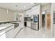Open kitchen area with stainless steel appliances, white cabinets, and a view of the staircase at 1460 Kensington Woods Dr, Lutz, FL 33549