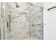 A modern shower features marble tile walls with gold fixtures, a built-in niche, and glass door at 1460 Kensington Woods Dr, Lutz, FL 33549