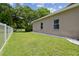 Side yard featuring well-manicured lawn, white fence, and natural landscaping, enhancing curb appeal at 1460 Kensington Woods Dr, Lutz, FL 33549
