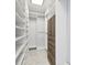 Well-organized walk-in closet with white shelving, wooden drawers, and ample storage at 1460 Kensington Woods Dr, Lutz, FL 33549