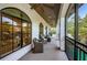 Covered balcony featuring wicker seating, ceiling fans, and views of the surrounding greenery and possible pool at 147 Bay Point Ne Dr, St Petersburg, FL 33704