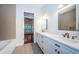 Bathroom with double vanity, stylish fixtures, and herringbone tile accent wall at 147 Bay Point Ne Dr, St Petersburg, FL 33704