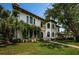 Stunning two-story home featuring arched windows, lush landscaping, and a brick pathway at 147 Bay Point Ne Dr, St Petersburg, FL 33704