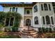 Elegant home entrance with arched doorway, lush greenery, and a brick pathway at 147 Bay Point Ne Dr, St Petersburg, FL 33704