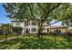 Elegant home with a black fence, manicured lawn, mature trees, and lush landscaping at 147 Bay Point Ne Dr, St Petersburg, FL 33704