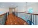 Elegant hallway with wood floors, iron railings, and a decorative chandelier, offering a bright and open space at 147 Bay Point Ne Dr, St Petersburg, FL 33704