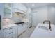 Well-equipped kitchen featuring white cabinets, gas cooktop, and marble backsplash at 147 Bay Point Ne Dr, St Petersburg, FL 33704