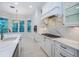 A modern kitchen showcasing white cabinets, a marble backsplash, and a gas cooktop at 147 Bay Point Ne Dr, St Petersburg, FL 33704