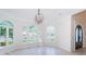 Spacious living room featuring arched windows for bright light, high ceilings, and neutral tile flooring at 147 Bay Point Ne Dr, St Petersburg, FL 33704
