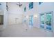 Bright living room featuring high ceilings, tile floors and multiple French door access points to outdoor living spaces at 147 Bay Point Ne Dr, St Petersburg, FL 33704