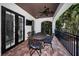Outdoor dining set on a covered patio with a ceiling fan, stone floors, pool view, and outdoor TV at 147 Bay Point Ne Dr, St Petersburg, FL 33704