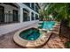 Backyard pool and adjacent hot tub with stucco balcony and lush tropical foliage at 147 Bay Point Ne Dr, St Petersburg, FL 33704