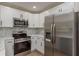 Modern kitchen with white cabinets, marble backsplash, stainless steel appliances, and ample counter space at 1524 Foggy Ridge Pkwy, Lutz, FL 33559