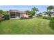 View of the screened lanai, red umbrella and pond from the expansive backyard at 1528 Riverdale Dr, Oldsmar, FL 34677