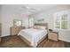 Bright bedroom featuring a queen-size bed, wood-look floors, and plantation shutters at 1528 Riverdale Dr, Oldsmar, FL 34677
