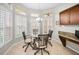 Bright breakfast nook features a round glass table, four chairs, built-in cabinets, and plantation shutters at 1528 Riverdale Dr, Oldsmar, FL 34677