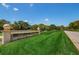 The East Lake Woodlands community sign is prominently displayed on a lush green lawn under a clear blue sky at 1528 Riverdale Dr, Oldsmar, FL 34677
