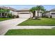 Exterior view of home with neutral paint, well-manicured landscaping, and a paved driveway at 1528 Riverdale Dr, Oldsmar, FL 34677
