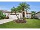 Charming home featuring a two-car garage, palm trees, and well manicured landscaping at 1528 Riverdale Dr, Oldsmar, FL 34677