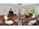 Cozy living room with hardwood floors, leather sofas, and a view of the screened-in lanai at 1528 Riverdale Dr, Oldsmar, FL 34677