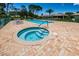 Inviting community pool and spa with brick surround and comfortable lounge chairs at 1528 Riverdale Dr, Oldsmar, FL 34677