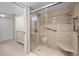 Large tiled walk-in shower features a glass door and bench, as well as convenient grab bars and storage shelves at 1581 Gulf Blvd # 403N, Clearwater Beach, FL 33767