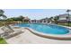 Relaxing pool area with lounge chairs, a tiki hut, and views of the adjacent canal and boat dock at 1581 Gulf Blvd # 403N, Clearwater Beach, FL 33767
