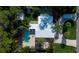 Aerial view of the property showcasing pool, covered patio, lush landscaping, and winding driveway at 1835 Michigan Ne Ave, St Petersburg, FL 33703