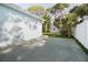 Side view of home featuring a concrete pad, shed, and lush greenery at 1835 Michigan Ne Ave, St Petersburg, FL 33703