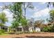 Wide view of backyard with mature trees, a screened patio and partial view of the home's exterior at 1852 Longview Ln, Tarpon Springs, FL 34689