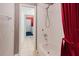 Well lit tiled bathroom featuring shower and tub combo with a red shower curtain at 1852 Longview Ln, Tarpon Springs, FL 34689