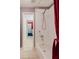 Well lit tiled bathroom featuring shower and tub combo with a red shower curtain at 1852 Longview Ln, Tarpon Springs, FL 34689