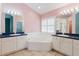Bright bathroom with large tub, tile flooring, and ample counter space with mirrors at 1852 Longview Ln, Tarpon Springs, FL 34689