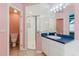 Bright bathroom with standing shower, toilet and a large vanity with mirrors at 1852 Longview Ln, Tarpon Springs, FL 34689