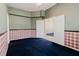 Comfortable bedroom with blue carpet, decorative wallpaper, and adjacent room view at 1852 Longview Ln, Tarpon Springs, FL 34689