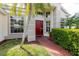 A bright red front door stands out with windows and neat landscaping along a brick walkway at 1852 Longview Ln, Tarpon Springs, FL 34689