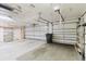 Spacious two-car garage with white doors, concrete floors and overhead lighting at 1852 Longview Ln, Tarpon Springs, FL 34689