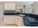Bright kitchen featuring white cabinets, and black countertops at 1852 Longview Ln, Tarpon Springs, FL 34689