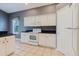 Charming kitchen featuring white cabinetry, black countertops, and modern appliances at 1852 Longview Ln, Tarpon Springs, FL 34689